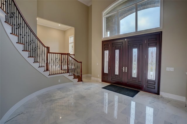 8498 Highgrove Ct, Grand Blanc, MI 48439 - foyer entrance featuring a high ceiling, marble tiled flooring, baseboards, stairs, and crown molding
