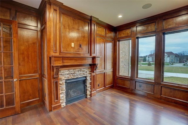 8498 Highgrove Ct, Grand Blanc, MI 48439 - unfurnished living room with a stone fireplace, dark wood-style flooring, a decorative wall, crown molding, and recessed lighting