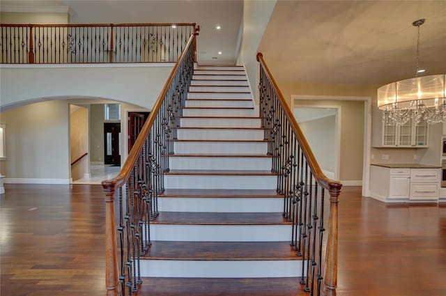 stairs featuring hardwood / wood-style flooring and a chandelier