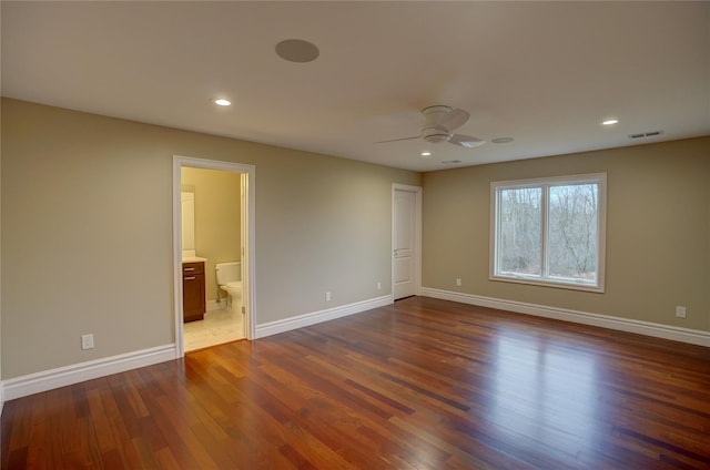 unfurnished bedroom with dark wood-type flooring, ceiling fan, and ensuite bathroom