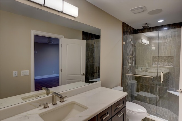 bathroom featuring vanity, toilet, and a shower with shower door