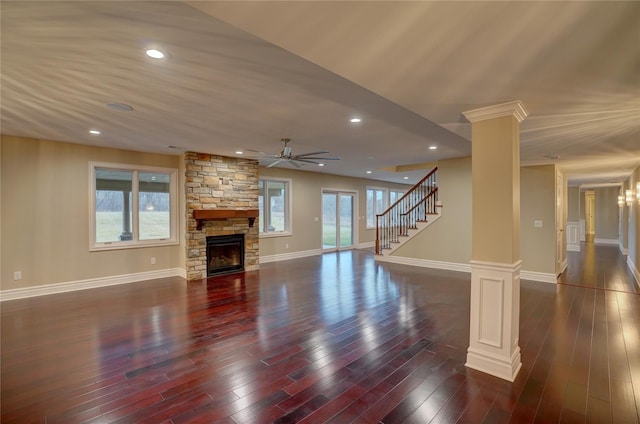 living room with dark hardwood / wood-style flooring, a fireplace, ceiling fan, and ornate columns