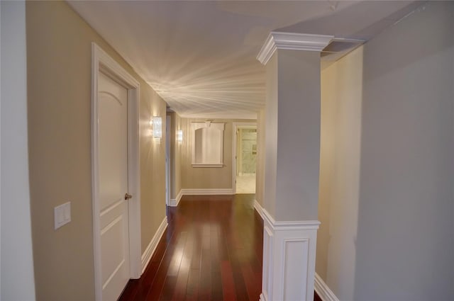 hallway featuring dark hardwood / wood-style flooring and ornate columns