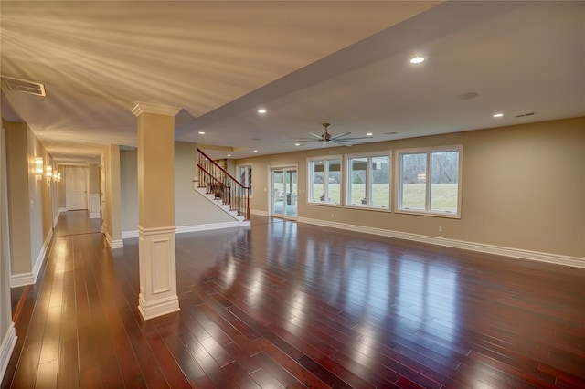 unfurnished living room featuring ceiling fan, dark hardwood / wood-style flooring, and decorative columns