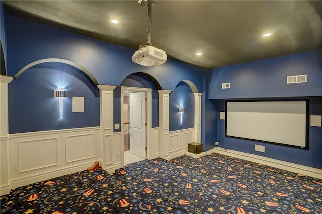 carpeted cinema room featuring decorative columns