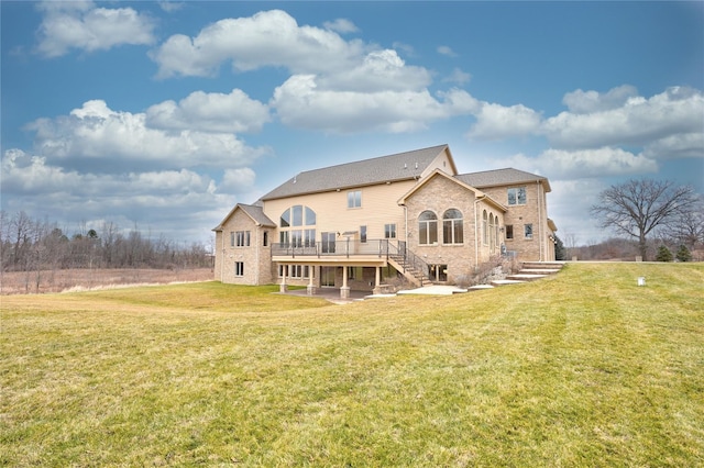 rear view of house featuring a deck and a lawn