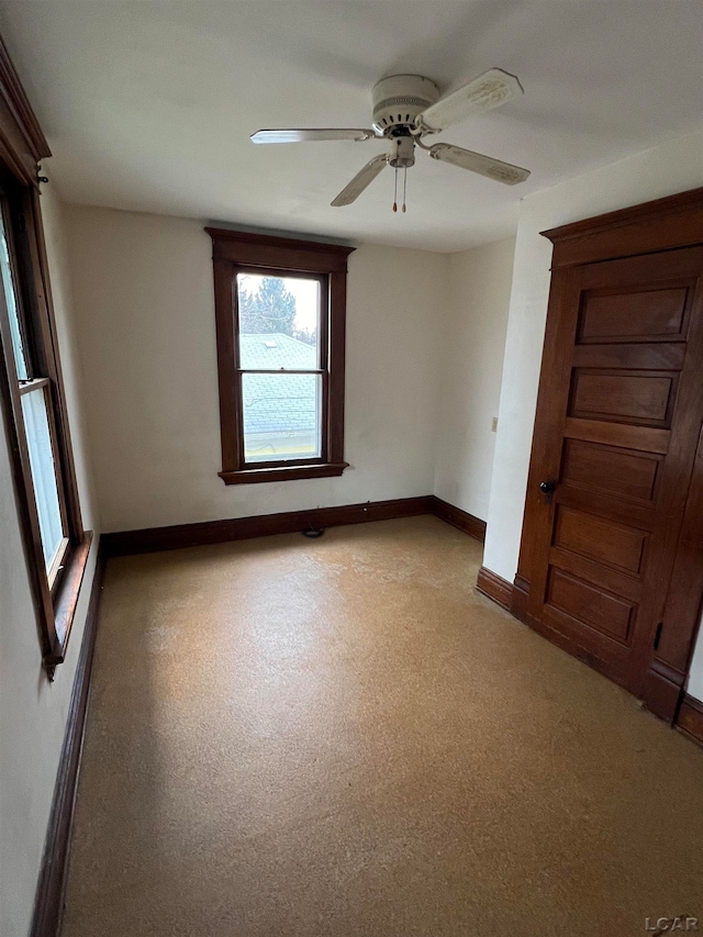 carpeted spare room featuring ceiling fan