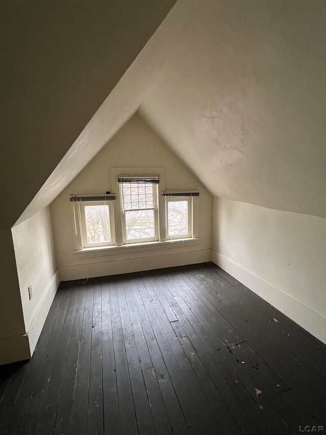 additional living space with dark hardwood / wood-style floors and lofted ceiling