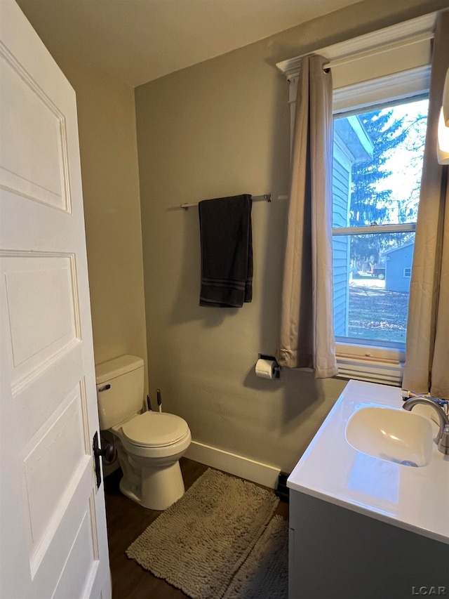 bathroom with hardwood / wood-style flooring, vanity, and toilet