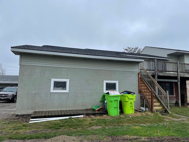 9470 Pontiac Lake Rd, White Lake, MI 48386 - view of home's exterior with a deck, stairs, and concrete block siding