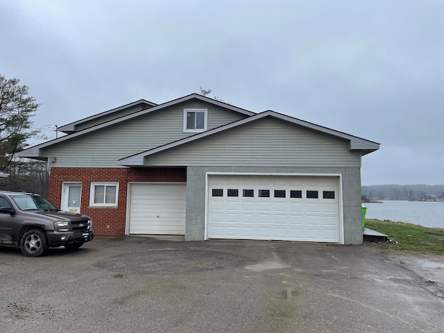 view of front of house featuring a garage and a water view