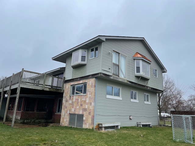 back of house with a lawn and a deck