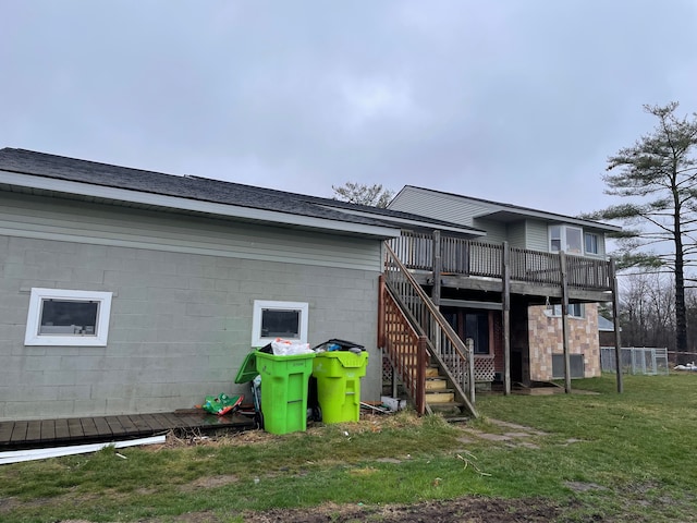 rear view of house with a deck and a lawn