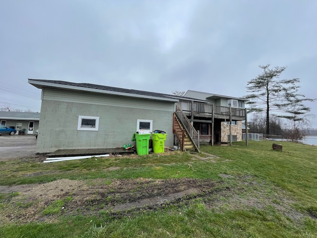 back of property with a deck and a lawn