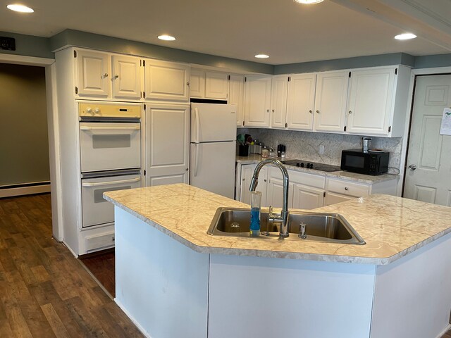 9470 Pontiac Lake Rd, White Lake, MI 48386 - kitchen with black appliances, a sink, a baseboard heating unit, dark wood-style flooring, and recessed lighting