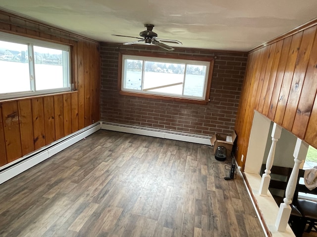 empty room with wood-type flooring, a healthy amount of sunlight, and brick wall