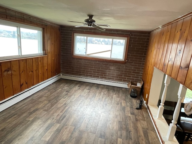 9470 Pontiac Lake Rd, White Lake, MI 48386 - empty room with ceiling fan, wood finished floors, wooden walls, baseboard heating, and brick wall