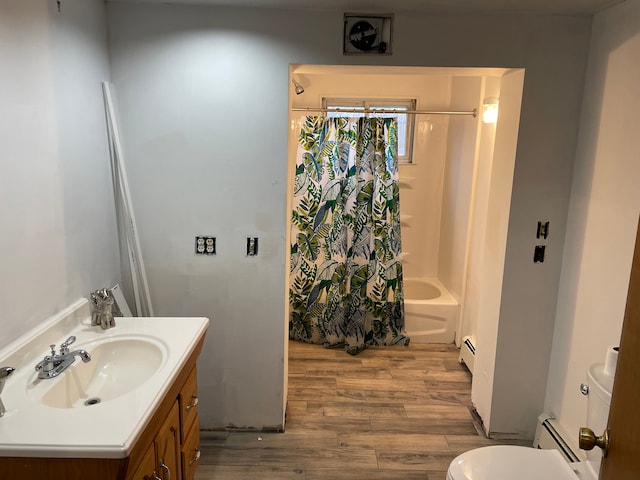 full bathroom with baseboard heating, toilet, shower / bath combo with shower curtain, vanity, and hardwood / wood-style flooring