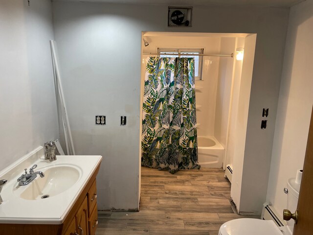 9470 Pontiac Lake Rd, White Lake, MI 48386 - bathroom with baseboard heating, vanity, toilet, wood finished floors, and shower / bathtub combination with curtain