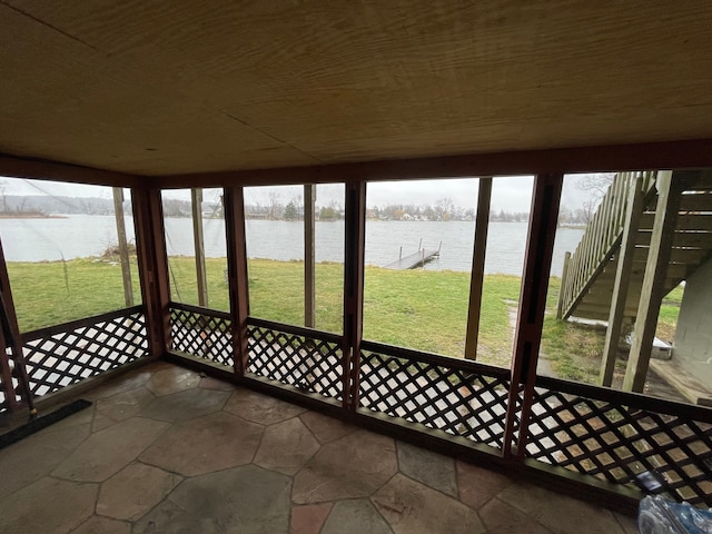 unfurnished sunroom with a water view