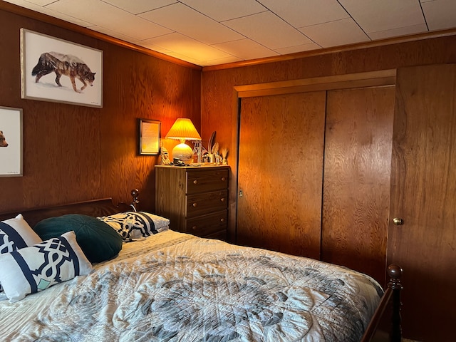 bedroom featuring wooden walls and a closet