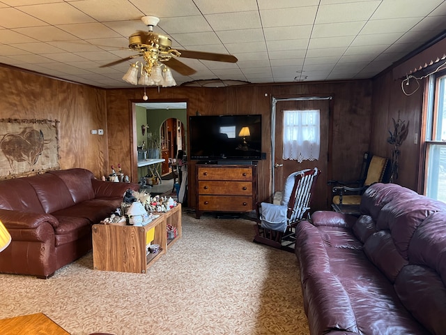 living room featuring ceiling fan and wood walls