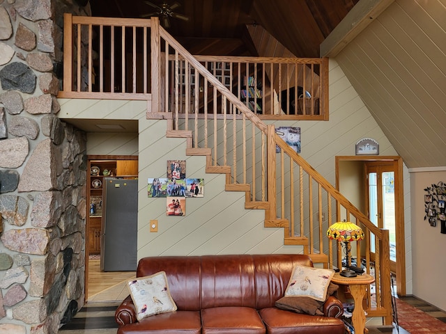 interior space with wood-type flooring, high vaulted ceiling, wooden walls, and beam ceiling