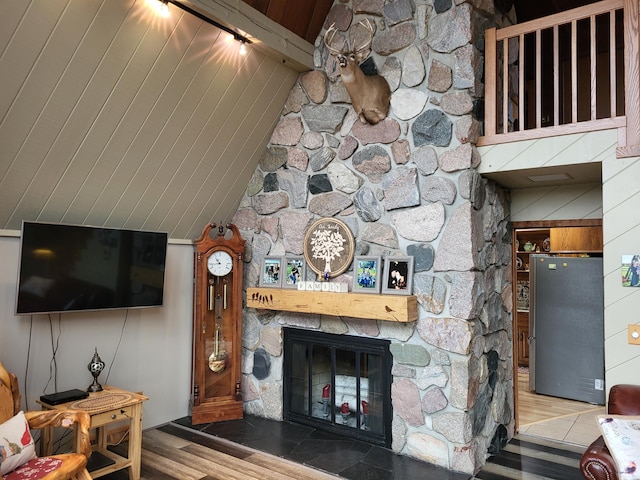 living room featuring a fireplace, wood-type flooring, wood walls, and beam ceiling