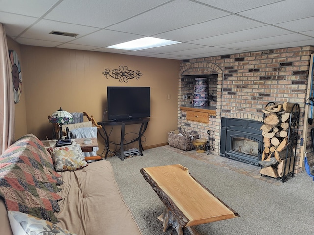 living room with carpet flooring, a paneled ceiling, and a brick fireplace