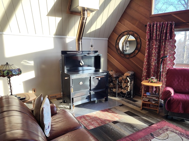 living room featuring a healthy amount of sunlight, dark hardwood / wood-style flooring, and wooden walls