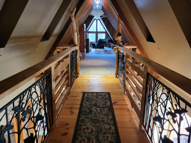 hall with light wood-type flooring and vaulted ceiling