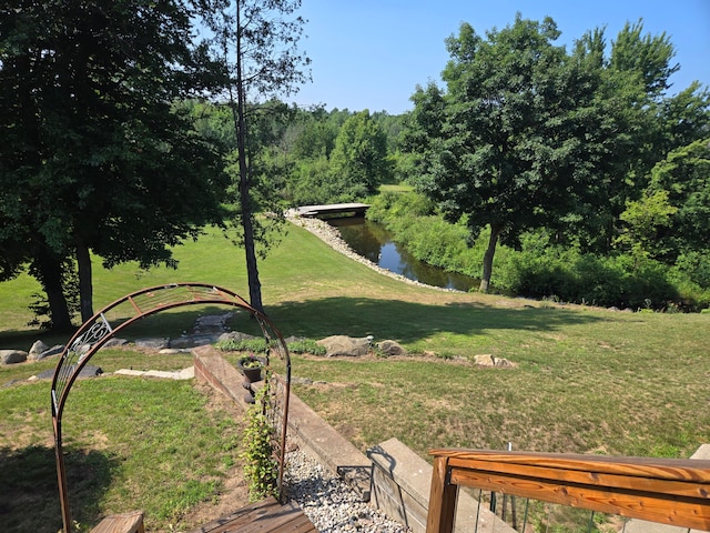 view of property's community with a yard and a water view