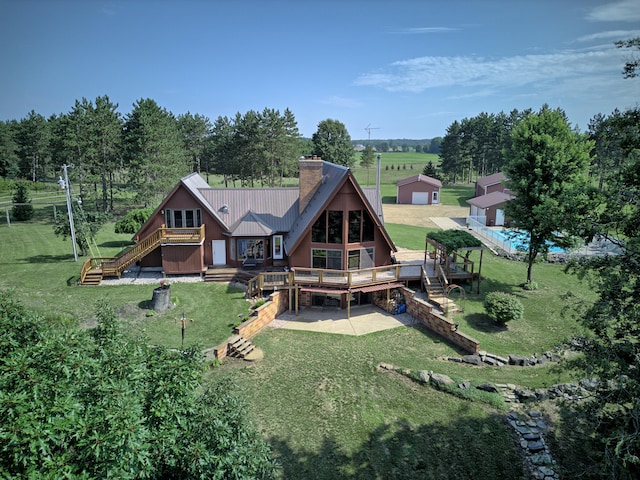 rear view of property featuring a garage, a lawn, and a wooden deck