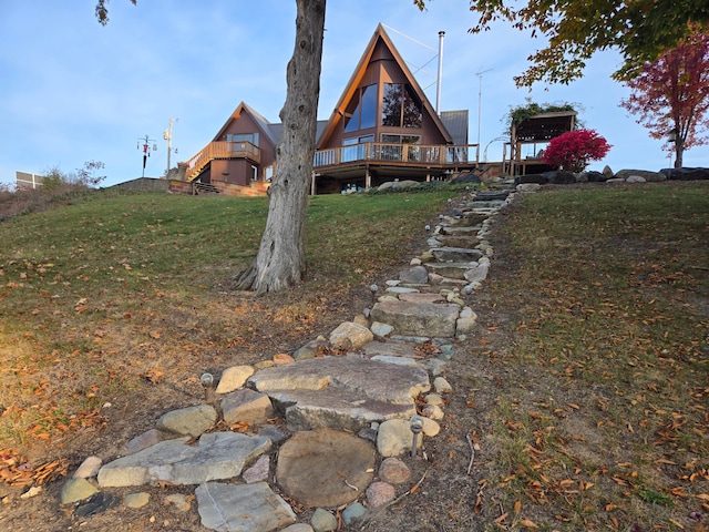 back of property with a lawn and a wooden deck