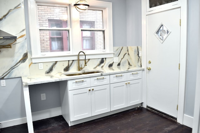 kitchen featuring light stone countertops, white cabinetry, sink, and dark wood-type flooring