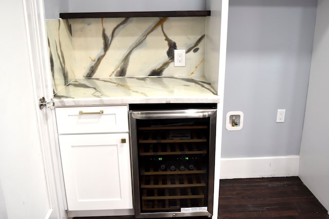 bar featuring light stone countertops, dark hardwood / wood-style flooring, white cabinetry, and wine cooler