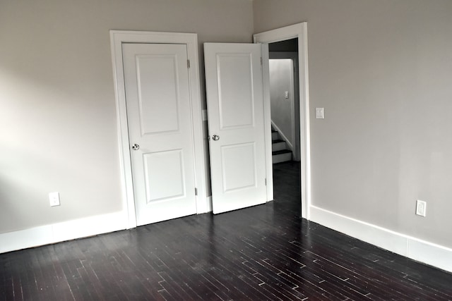 unfurnished bedroom with dark hardwood / wood-style flooring