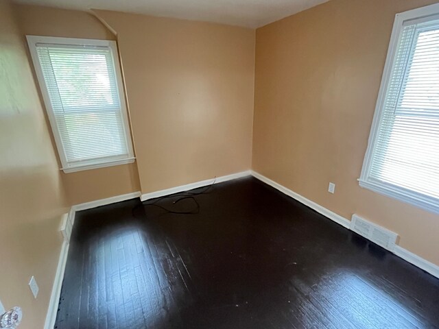 18903 Evergreen Rd, Detroit, MI 48219 - empty room featuring dark wood-style floors, plenty of natural light, and baseboards
