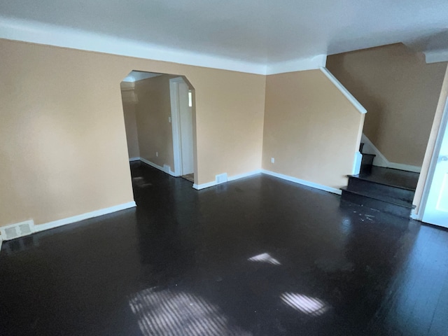 18903 Evergreen Rd, Detroit, MI 48219 - unfurnished room with arched walkways, stairway, dark wood finished floors, and baseboards