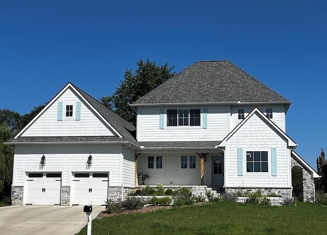 front facade with covered porch, a garage, and a front yard