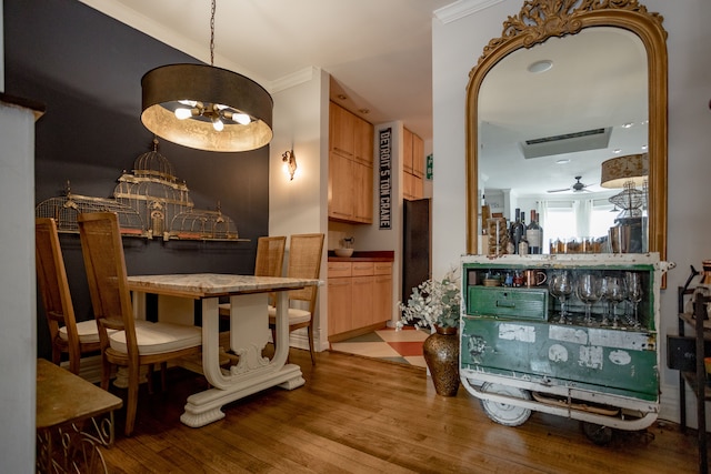 bar featuring crown molding, light hardwood / wood-style flooring, ceiling fan with notable chandelier, and light brown cabinets