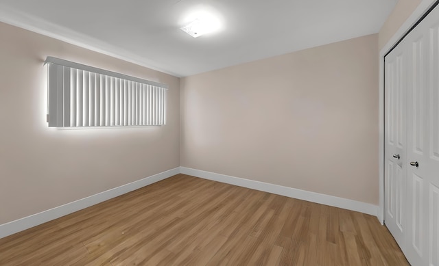 unfurnished bedroom with a closet and light wood-type flooring