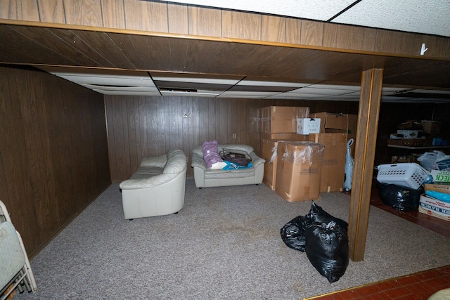 basement featuring carpet flooring and wooden walls