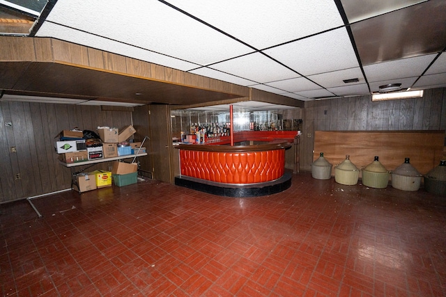 bar with a paneled ceiling and wooden walls