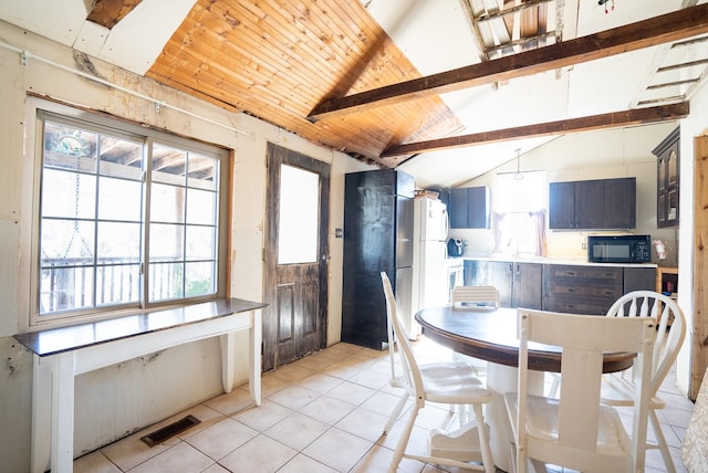 dining area with a healthy amount of sunlight, light tile patterned floors, and lofted ceiling with beams