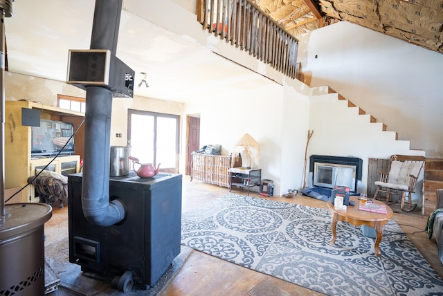 living room with a wood stove and high vaulted ceiling