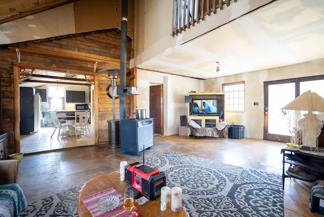 living room featuring wooden walls and high vaulted ceiling