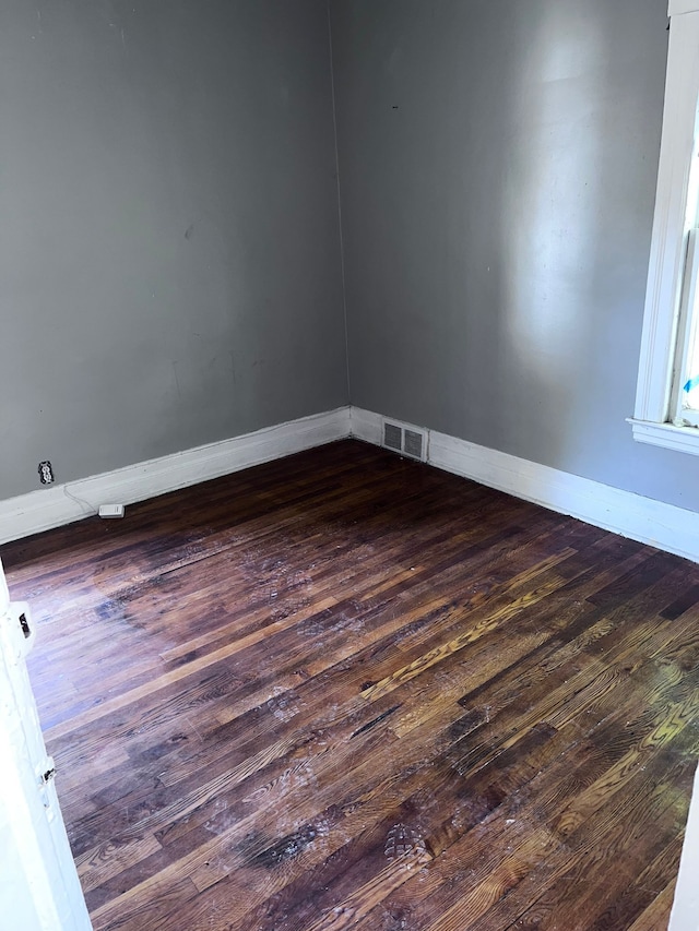 spare room featuring dark wood-type flooring