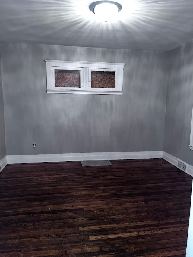 empty room with dark hardwood / wood-style flooring