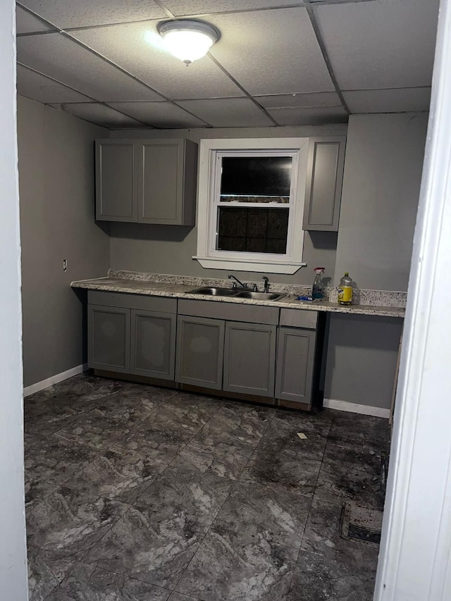 kitchen featuring gray cabinets, a paneled ceiling, and sink